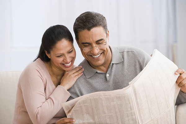 Hispanic couple reading newspaper 2018